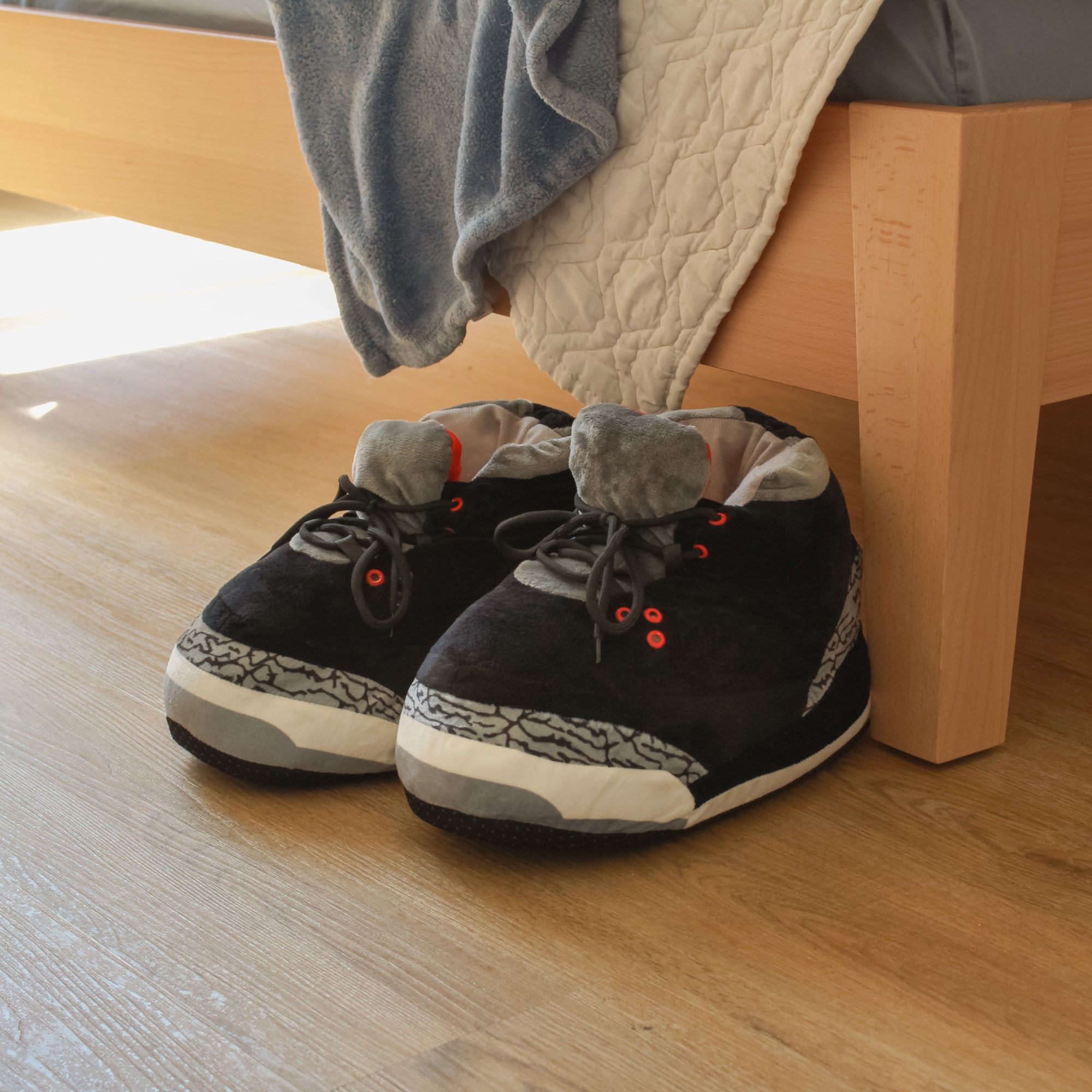 Yours 2 Keep Black Marble Sneaker Slippers next to a bed