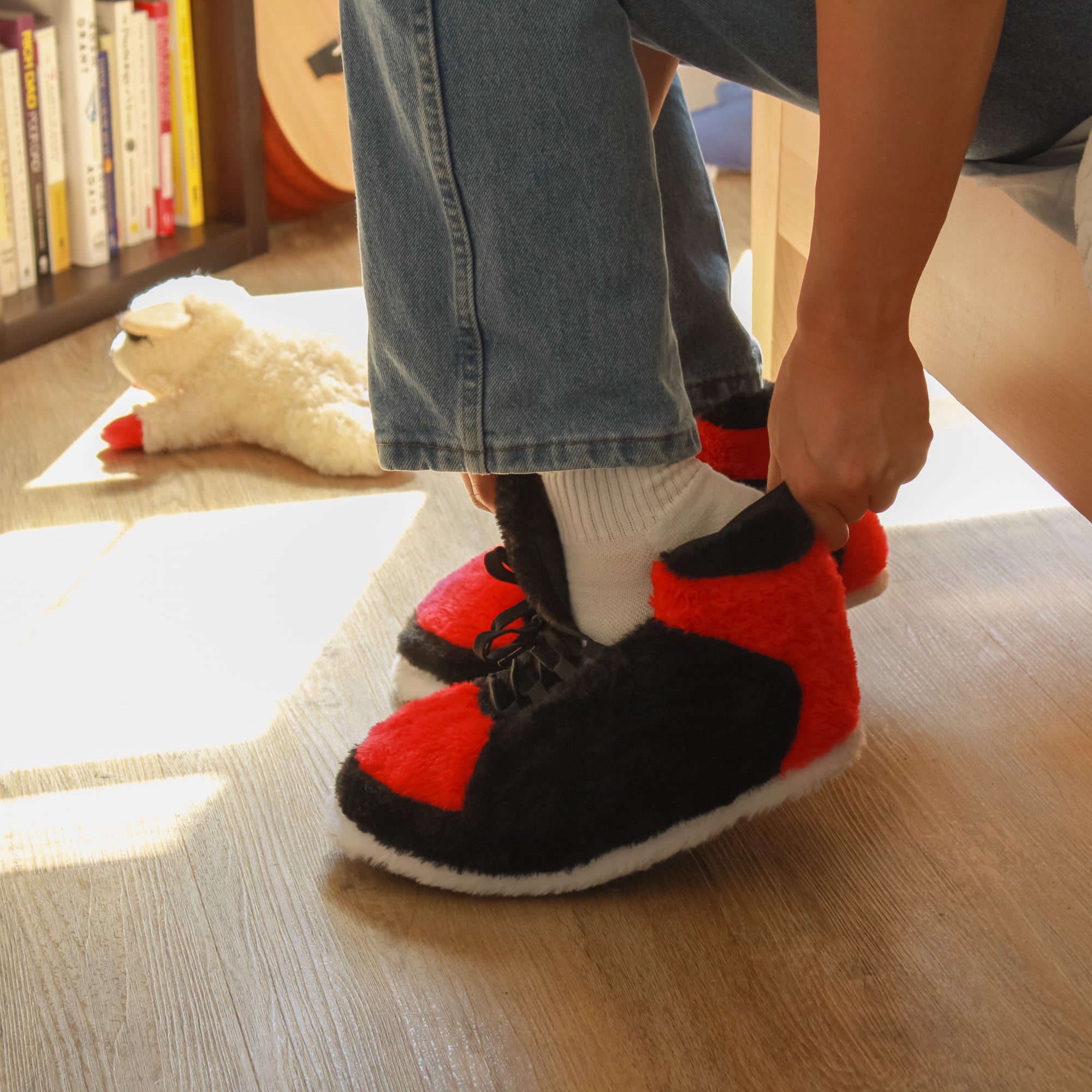 Model putting on Yours 2 Keep Bred Sneaker Slippers